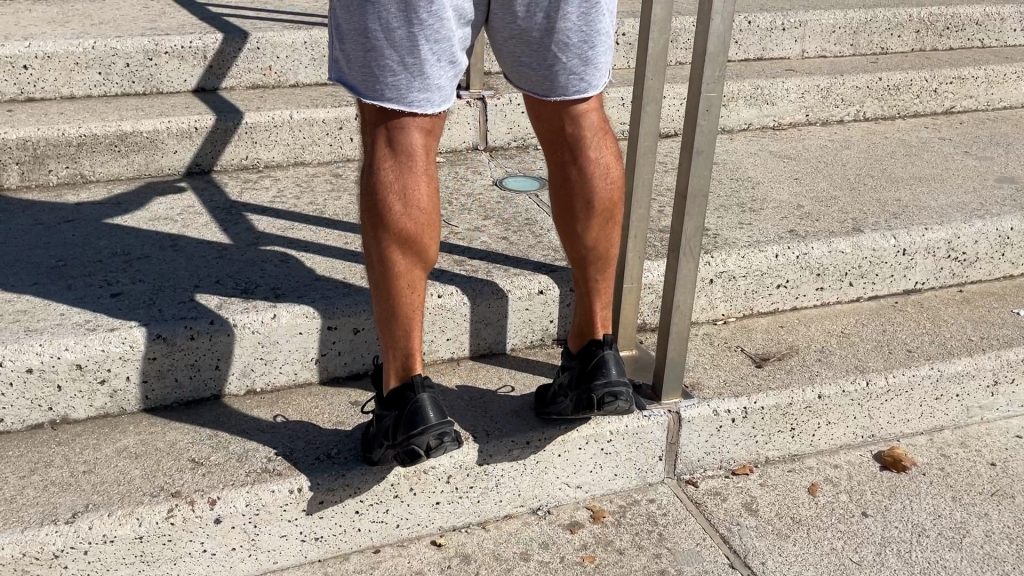 Mollets d'un homme faisant un mouvement d'extension mollets lors de son entraînement de Street Workout