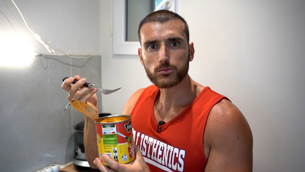 Homme mangeant des raviolis directement dans une boîte de conserve