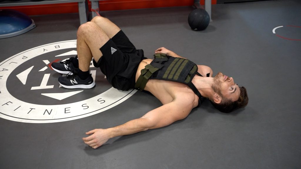 Homme allongé par terre à la fin de séance de musculation en salle intense