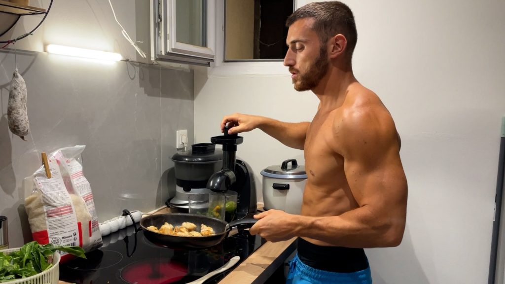 Homme de profil dans sa cuisine en train de cuire du poulet avec une poêle à la main