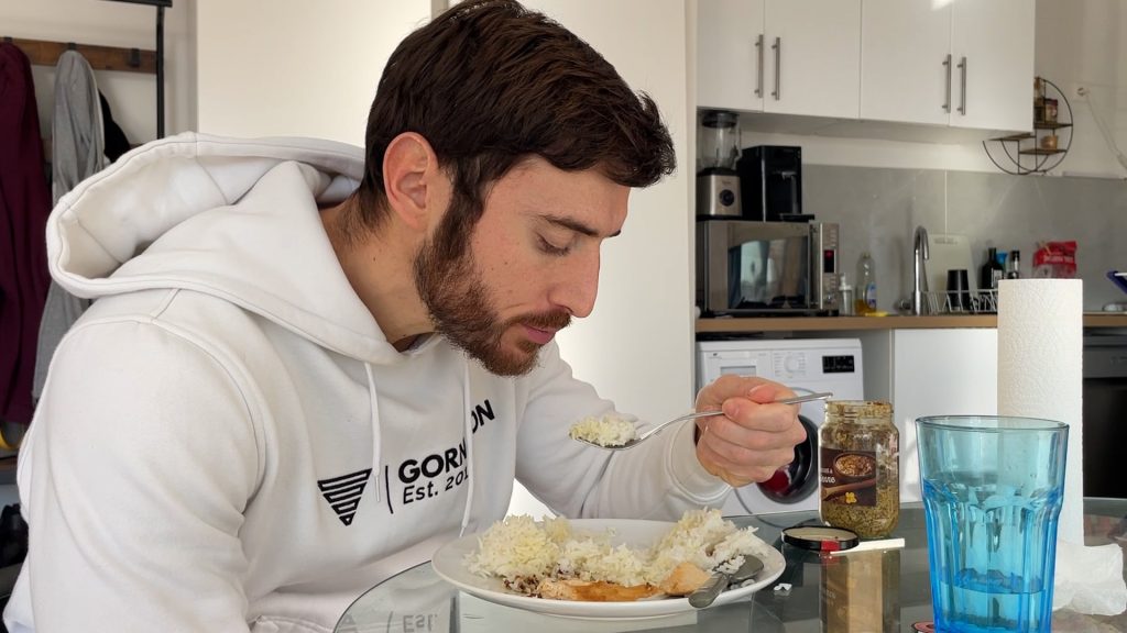 Homme en train de manger un plat de riz avec du poulet