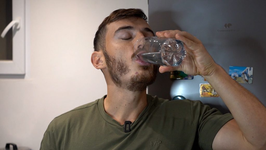 Homme en train de boire un verre d'eau