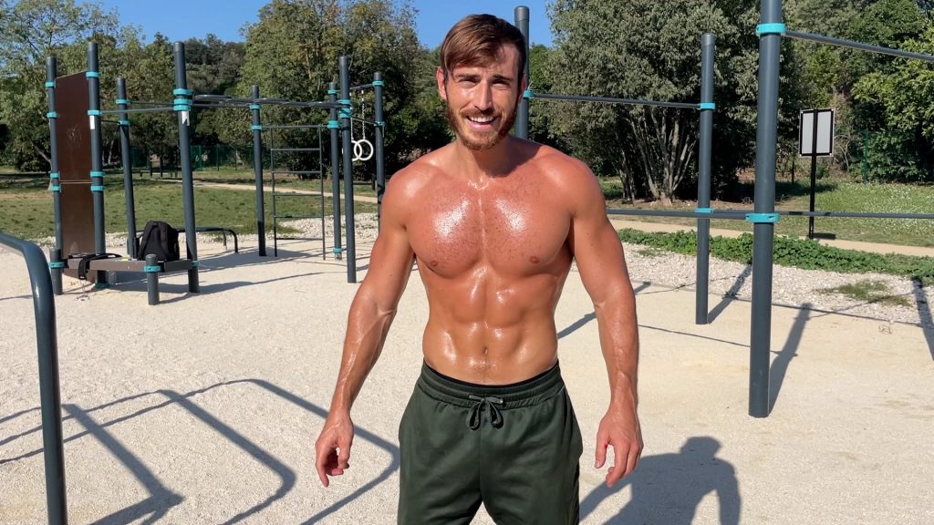 Homme musclé et sec transpirant dans un parc de street workout après son entraînement